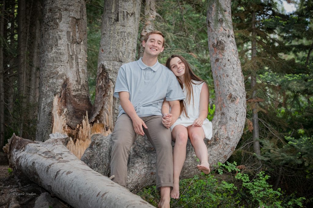 A happy couple is sitting on a tree