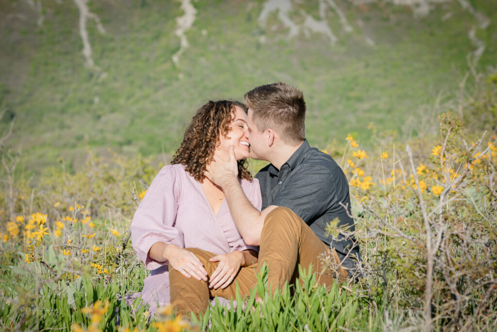 A couple is kissing in beautiful field